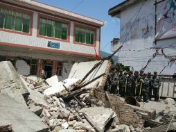 Elementos de rescate y del ejército chino continuán con los trabajos de rescate de personas atrapadas en la estructuras colapsadas. AP /