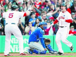 Daniel Nava (derecha) pisa el home y es felicitado por su compañero Jonny Gomes, tras conectar el cuadrangular de la victoria. AP /