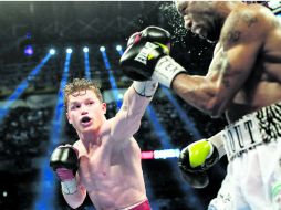 A distancia. Saúl Álvarez lanza un golpe al rostro de Austin Trout. AP /