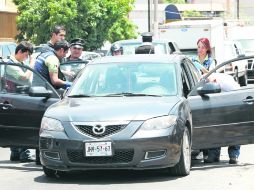 Escena del crimen. Personal forense trabaja en el vehículo atacado por un gatillero desde una motocicleta, en la Colonia General Real. EL INFORMADOR /