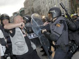 Un manifestante se enfrenta a varios miembros de la Policía Nacional en la plaza de Neptuno. EFE /
