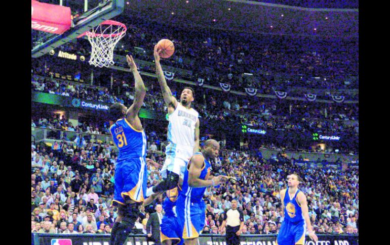 Wilson Chandler (centro) penetra en la pintura para realizar un tiro a la canasta ante la marca de Festus Ezeli (31) de Golden State. EFE /