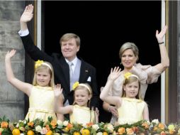 Guillermo Alejandro de Holanda, su esposa y sus hijas saludan desde el balcón del palacio real. EFE /