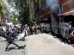 Un jóven anarquista arroja piedras en contra de la contención de los Granaderos. SUN /