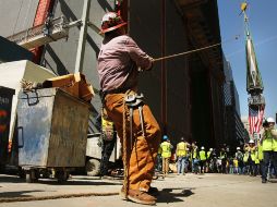 Operarios suben la última pieza de la antena del rascacielos One World Trade Center. AP /