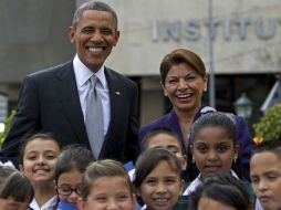 Barack Obama y Laura Chinchilla posan junto a un grupo de niños en la llegada del mandatario a Costa Rica. AP /