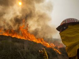Ocho helicópteros, seis avionetas y alrededor de mil bomberos combaten un fuego que hasta ahora ha destruido 15 edificios. AP /