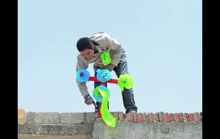 CON EL ORGULLO EN ALTO. Colocar la cruz para que los proteja en la obra es una costumbre que se repite año con año. EL INFORMADOR /