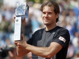 El encuentro germano dura menos de hora y media y aquí el ganador presume su trofeo. AP /