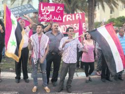 Árabes residentes en Haifa ondean banderas sirias en protesta contra el ataque en Damasco. AFP /
