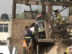 Elementos de Protección Civil revisan una de las viviendas dañadas por la explosión. NTX /