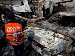 Un oficial de policía hace guardia cerca del lugar donde un camión cisterna de gas explotó en el municipio mexiquense de Ecatepec. AFP /