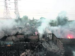 SAN PEDRO XALOSTOC . Uno de los dos tanques que transportaba el camión cisterna se incrustó en el pueblo. Hay 36 personas heridas. AFP /