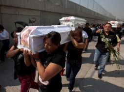 Familiares y amigos participan en los funerales de algunas víctimas mortales de la explosión en el municipio mexiquense de Ecatepec. AP /
