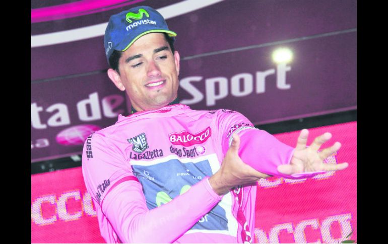 Beñat Intxausti Elorriaga se viste en el podio la camiseta rosa de líder. AP /