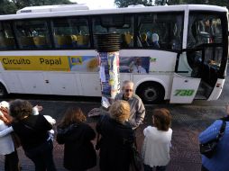 Las personas inscriptas al ''Papa Tour'' esperan para abordar el autobús. AFP /