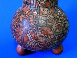 El objeto se encuentra decorado con escenas alusivas al sacrificio ritual de un personaje y un rito de cremación.  /