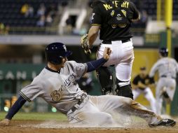 Logan Schafer de los Cerveceros de Milwaukee realiza anotación durante el partido contra los Piratas de Pittsburg. AP /
