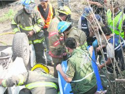 DESTRUIDO. Rescatistas trabajan en uno de los vehículos, sobre la carretera Guadalajara-Morelia. EL INFORMADOR /