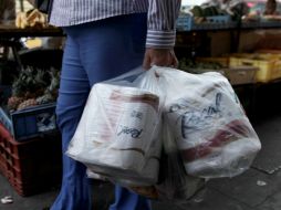 Imagen de una mujer que compró papel higiénico en una tienda privada en Caracas. AP /