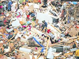 Sin descanso. Socorristas de diversos cuerpos de rescate buscan entre los escombros de viviendas a sobrevivientes en Granbury. AP /