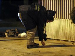 Agentes policiacos investigan el asesinato para esclarecer el crimen. ARCHIVO /