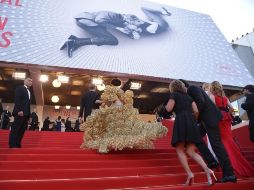 Una modelo luciendo un vestido hecho con cajas de galletas, llega a un evento en Cannes. AFP /