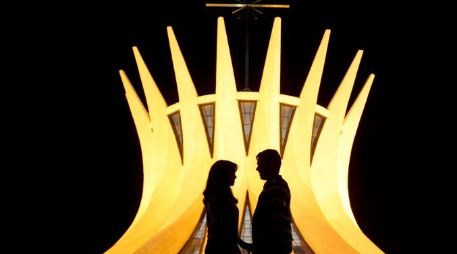 La silueta de una pareja se recorta frente a la catedral de Brasilia, diseño del arquitecto Niemeyer. ARCHIVO /