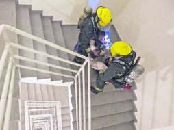 Extenuante. Bomberos bajan por las escaleras a un supuesto lesionado. EL INFORMADOR /