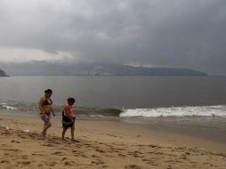 Dos mujeres caminan por la playa en el puerto de Acapulco, donde se observa la nubosidad propiciada por el huracán ''Bárbara''. NTX /