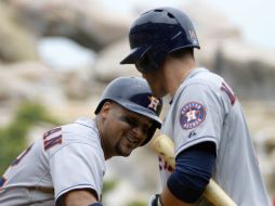 El recpetor Carlos Corporan (i) pega batazo de cuatro esquinas en el primer episodio, sin corredores en el camino. AP /