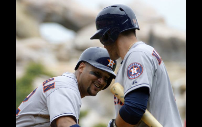 El recpetor Carlos Corporan (i) pega batazo de cuatro esquinas en el primer episodio, sin corredores en el camino. AP /