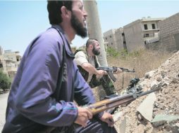 Combatientes rebeldes sirios del batallón ''Mártires de Maaret al-Numan'', al acecho en la ciudad sureña de Maaret al-Numa. AFP /