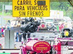 Rescatistas laboran en la zona del accidente, en el Centro del Estado. AFP /