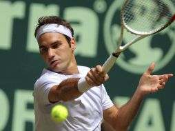 Roger Federer regresa un pase a su rival alemán durante el encuentro en la ciudad de Halle. AP /