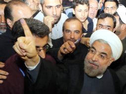 Rohani muestra su dedo con tinta tras haber votado. EFE /