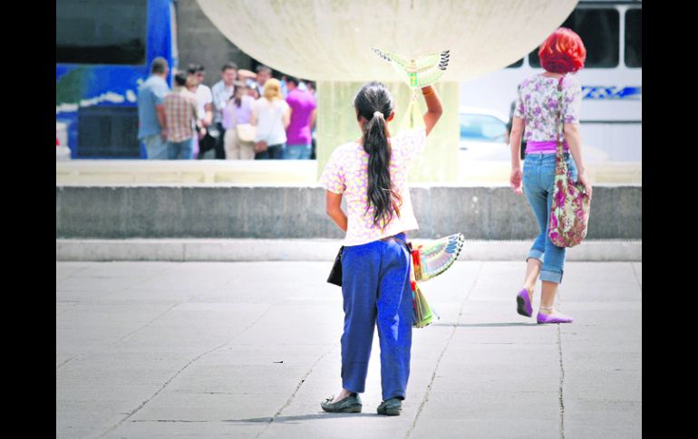 NIÑA VENDEDORA. Una menor de edad trabaja en el comercio informal vendiendo aves de juguete en la Plaza de la Liberación. EL INFORMADOR /