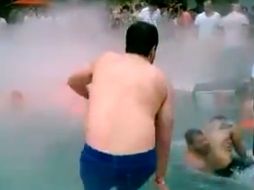 Momento en el que asistentes a la ''pool party'' rescatan a jóvenes intoxicados or el nitrógeno que es lanzado a la alberca. ESPECIAL /