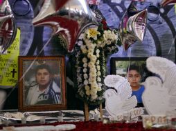 Familiares de las víctimas hacen un memorial a las afueras del News Divine. AP /