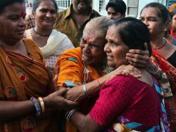 Peregrinas se abrazan tras ser separadas de sus familiares debido al monzón. AP /