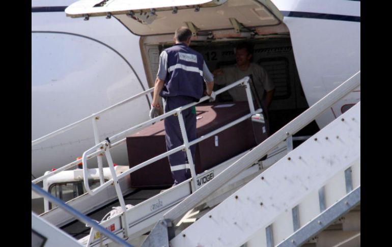 Trabajadores en el aeropuerto colocando en el avión un féretro identificado como el de Gandolfini. EFE /