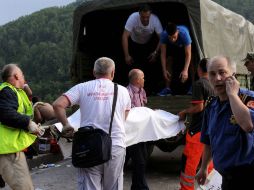 Rescatistas sacan los cuerpos de los fallecidos del barranco de dónde cayó el camión. AP /