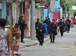 Miembros del Batallón de Operaciones Especiales recorren una favela durante un operativo. AFP /