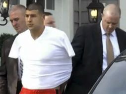 El ex jugador salió de su casa esposado con los brazos en la espalda y metidos dentro de una camiseta blanca. AP /