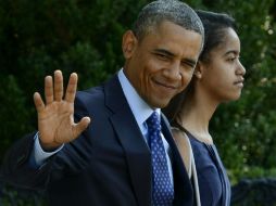 Barack Obama es acompañado por una de sus hijas mientras pasea por el lugar. EFE /
