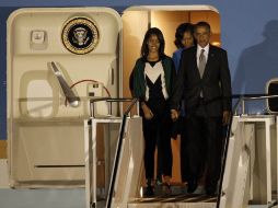 Barack Obama (d), su esposa, Michelle Obama (c), y sus hijas, Malia (i) y Sasha (no visible en la foto), llegan a Sudáfrica. EFE /