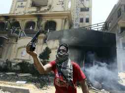 Un opositor sostiene una pistola  incautada en un asalto a su sede principal en al-Moqattam. EFE /