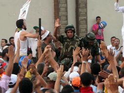 Algunos de los manifestantes portaban armas, por lo cual, personalidades del pueblo intervienen para disolver la concentración. EFE /
