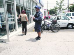 DELITO CONSUMADO. Un policía trabaja en una sucursal bancaria de la calle Gante, en el Sector Reforma, Guadalajara. EL INFORMADOR /