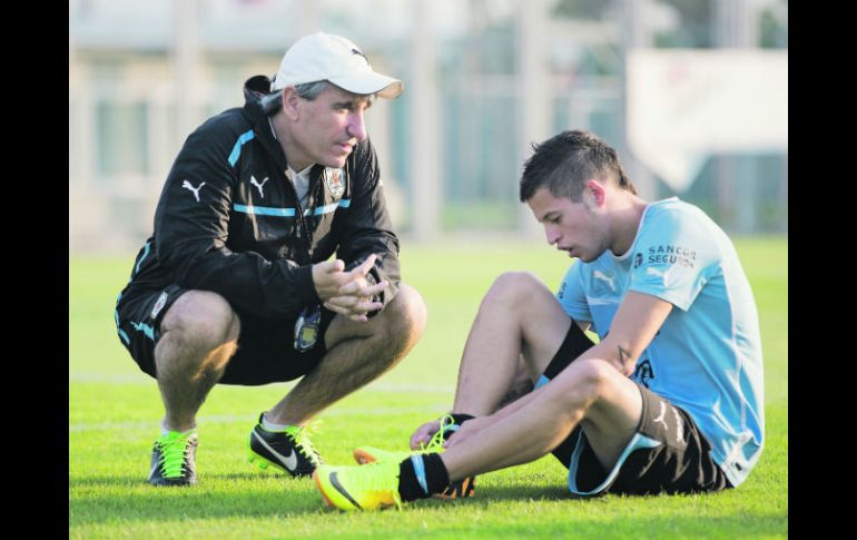Juan Verzeri, entrenador de la Selección charrúa, le da indicaciones a su estrella, Nicolás López, durante la práctica de ayer. AP /